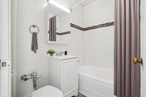 Denver apartment for rent - A white bathroom with a toilet, sink, and bathtub.