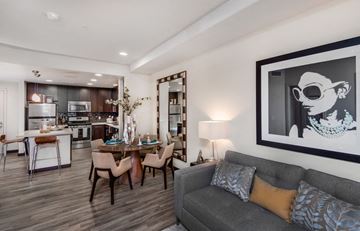 West Hollywood apartment for rent - A modern living room with a grey couch and a dining table.