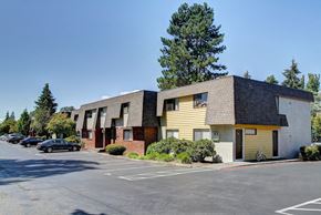 Bellevue apartment for rent - A parking lot in front of a building with a car parked.