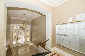San Francisco apartment for rent - A hallway with a chandelier and a wall of binders.