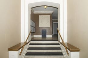 San Francisco apartment for rent - A hallway with a staircase and a clock on the wall.