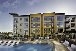 Hillsboro apartment for rent - a building with a pool and chairs in front of it
