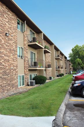 West Des Moines apartment for rent - an apartment building with a lawn and cars parked in front
