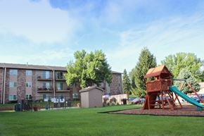 West Des Moines apartment for rent - a playground with a tree house in front of an apartment building