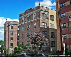 Hackensack apartment for rent - A large brick building with a tree in front of it.