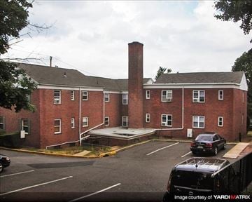 Hasbrouck Heights apartment for rent - A brick building with a parking lot in front.