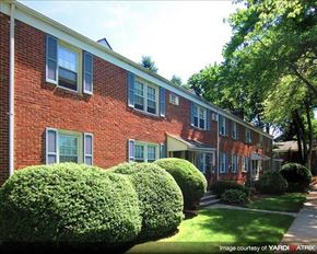 Bound Brook apartment for rent - A red brick building with green bushes in front.