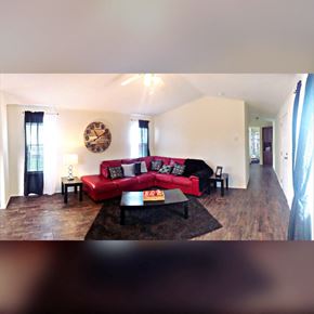 Montrose apartment for rent - a living room with a red couch and a clock on the wall