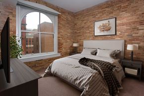 Baltimore apartment for rent - a bedroom with a bed and a brick wall