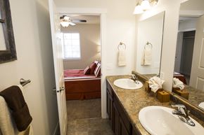 Dickinson apartment for rent - Image of bathroom with master bedroom containing two sinks, two mirrors, and towel rack