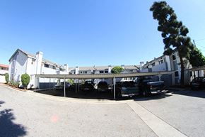 Paramount apartment for rent - a parking lot with cars in front of a building