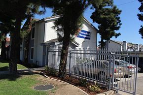 Paramount apartment for rent - a house with a car parked in front of a fence