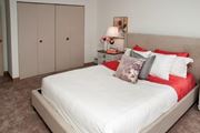 Bloomington apartment for rent - a bedroom with a white bed and red pillows