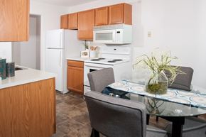 Coon Rapids apartment for rent - a kitchen with white appliances and a table with chairs
