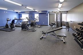 Savage townhouse for rent - a gym with cardio equipment and weights in a building with blue walls