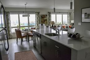 Seattle apartment for rent - A modern kitchen with a large island and a dining table with chairs.
