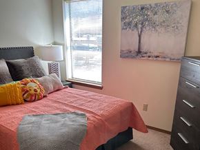 Fayetteville apartment for rent - a bedroom with a bed and a painting on the wall