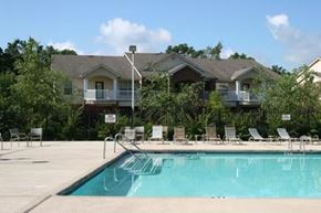 Fayetteville apartment for rent - A swimming pool in front of a house with a sunny sky.