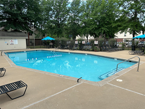 Bentonville apartment for rent - a resort style pool with chairs and umbrellas and trees