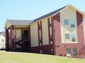 Fayetteville apartment for rent - A red and white building with a staircase leading to the second floor.