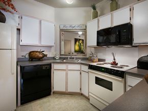Oxford apartment for rent - a kitchen with white cabinets and black appliances
