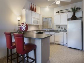 Fayetteville apartment for rent - a kitchen with white appliances and a counter with two chairs