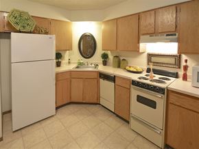 Fayetteville apartment for rent - a kitchen with white appliances and wooden cabinets