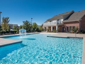 Norman apartment for rent - a swimming pool with a fountain in front of a house