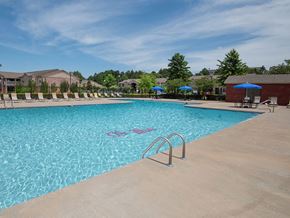 Oxford apartment for rent - a swimming pool with chairs and umbrellas in front of a building