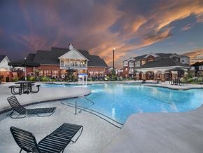 Bentonville apartment for rent - a large swimming pool with lounge chairs at sunset