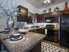 Bentonville apartment for rent - a kitchen with granite counter tops and black appliances