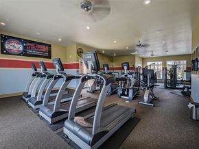 Bentonville apartment for rent - a gym with cardio equipment and a sign on the wall
