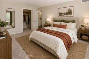 Nottingham apartment for rent - A bedroom with a large bed and a mirror on the wall.