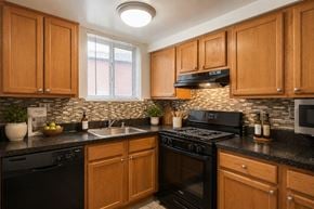 Nottingham apartment for rent - A kitchen with black appliances and wooden cabinets.