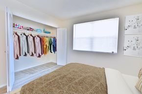 Catonsville apartment for rent - a bedroom with a bed and a closet with clothes on a rack
