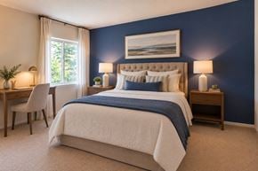 Glen Burnie apartment for rent - A bedroom with a large bed and a painting on the wall.