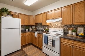 Glen Burnie apartment for rent - A kitchen with wooden cabinets and a white refrigerator.