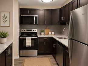 Baltimore apartment for rent - A modern kitchen with dark wood cabinets and stainless steel appliances.