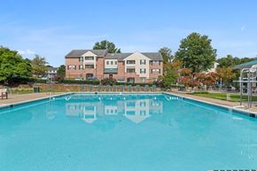 Baltimore apartment for rent - A large swimming pool in front of a multi-story building.