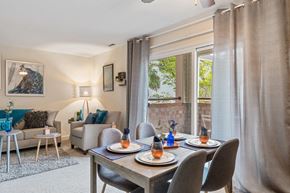 Baltimore apartment for rent - A dining room with a table set for two and a view of a garden outside.