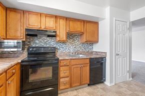 Westminster apartment for rent - a kitchen with black appliances and wooden cabinets