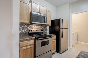Garner apartment for rent - a kitchen with stainless steel appliances and wood cabinets