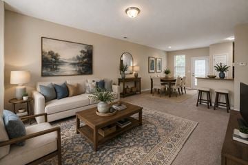 Raleigh townhouse for rent - A living room with a large painting on the wall and a coffee table in the center.