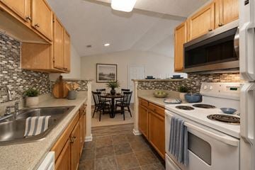 Rock Hill apartment for rent - A kitchen with wooden cabinets and a white stove top oven.