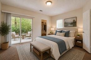 Rock Hill apartment for rent - A bedroom with a large bed and a view of the outdoors through the sliding glass doors.