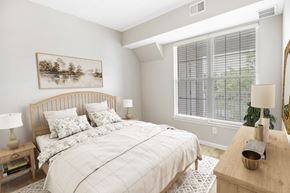 Bear triplex for rent - A bedroom with a large bed and a painting on the wall.