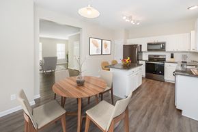 Bear triplex for rent - A modern kitchen with a dining table and chairs.