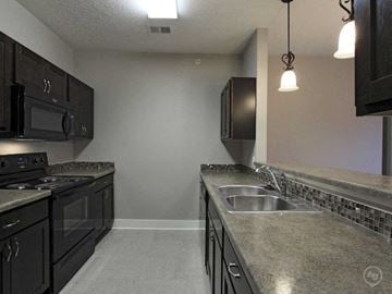 Lincoln apartment for rent - A kitchen with black cabinets and a granite countertop.