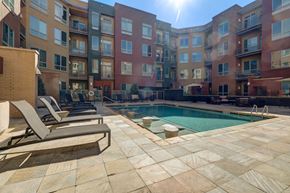Boulder apartment for rent - A sunny day at a poolside with lounge chairs and apartment buildings in the background.