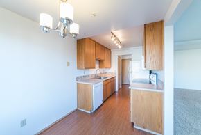 Seattle apartment for rent - a kitchen with wood flooring and white appliances and wooden cabinets